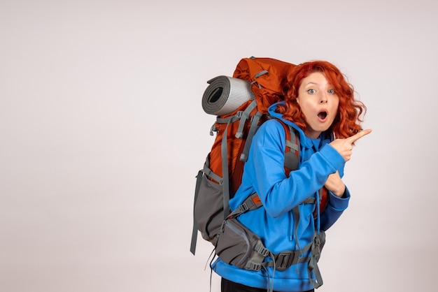 Front view female tourist going in mountain trip with backpack