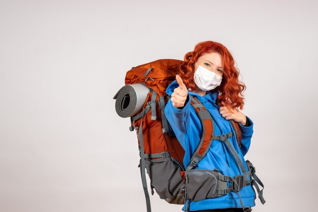 Front view female tourist going in mountain trip with backpack