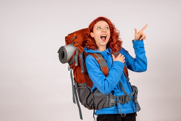 Front view female tourist going in mountain trip with backpack