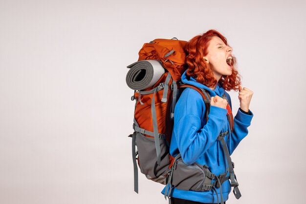 Front view female tourist going in mountain trip with backpack