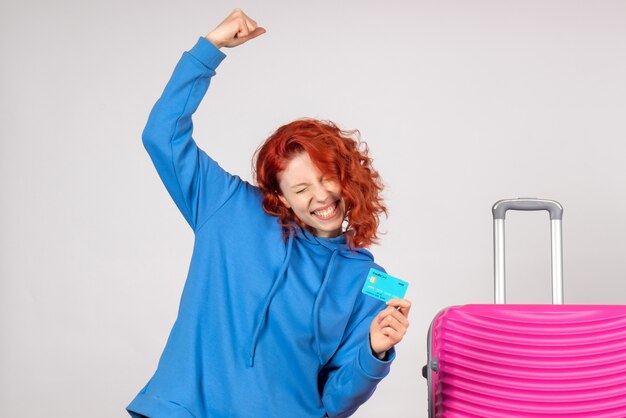 Front view female tourist holding bank card and rejoicing