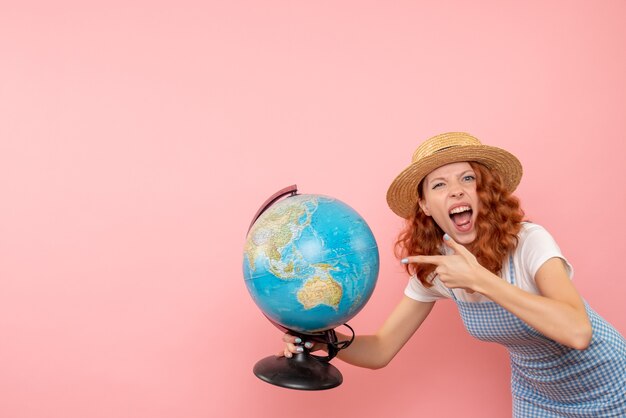 Женщина-туристка, держащая земной шар, вид спереди