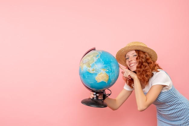 Бесплатное фото Женщина-туристка, держащая земной шар, вид спереди