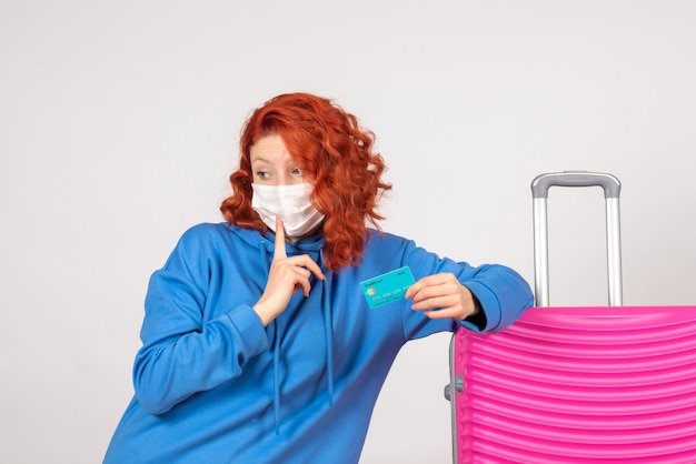 Foto gratuita turista femminile di vista frontale nella maschera che tiene carta di credito