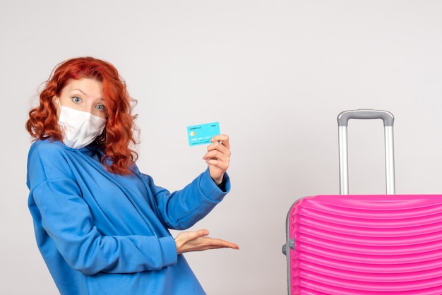 Free photo front view female tourist in mask holding bank card