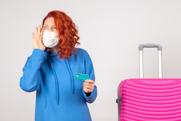 Foto gratuita turista femminile di vista frontale nella maschera che tiene carta di credito