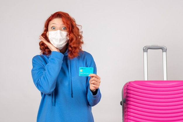 Free photo front view female tourist in mask holding bank card