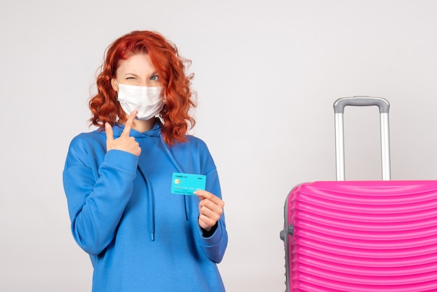 Free photo front view female tourist in mask holding bank card