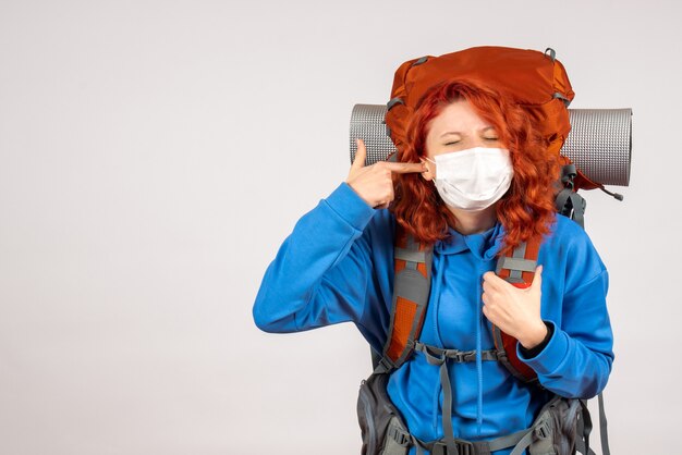 Front view female tourist in mask with backpack