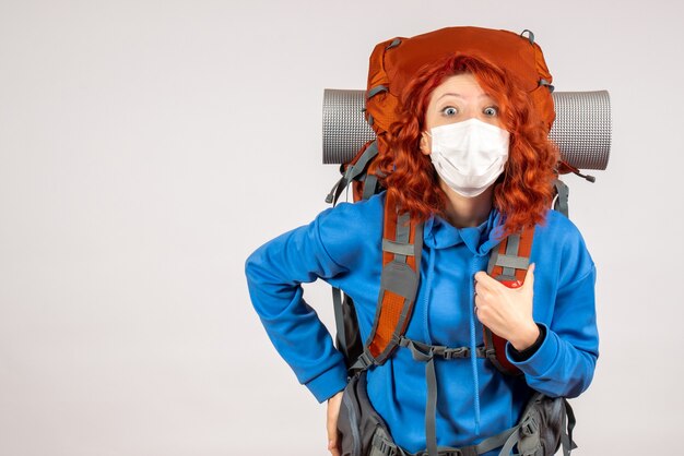 Front view female tourist in mask with backpack