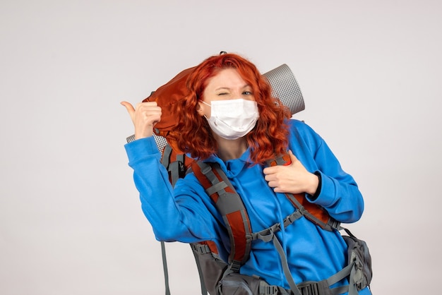 Front view female tourist in mask with backpack