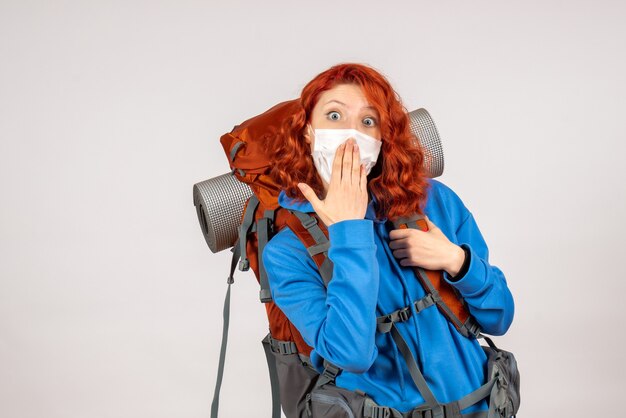 Front view female tourist in mask with backpack