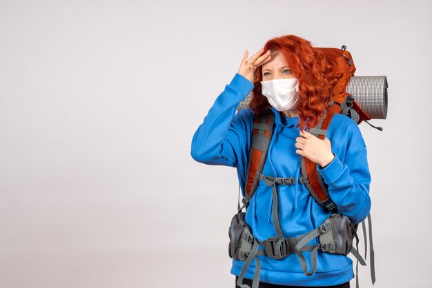 Front view female tourist in mask with backpack