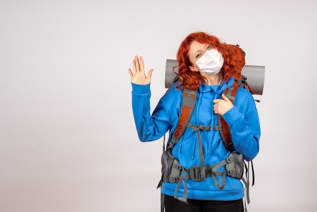Женщина-туристка в маске с рюкзаком, вид спереди
