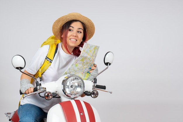 Front view female tourist sitting on motorcycle with map white wall