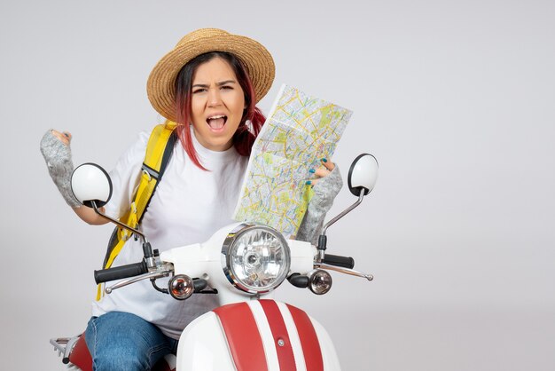 Front view female tourist sitting on motorcycle with map white wall