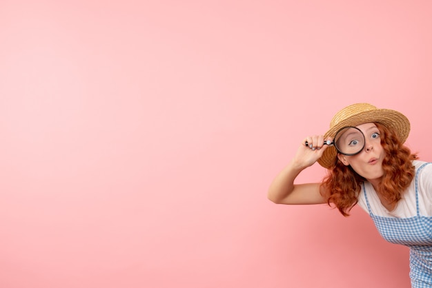 Foto gratuita turista femminile di vista frontale che cammina intorno con la lente d'ingrandimento