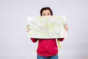 Free photo front view female tourist with backpack and map on white wall