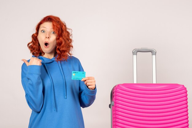 Front view female tourist with bank card and pink bag