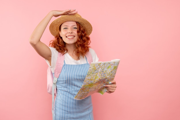 外国で方向を見つけようとしている地図と正面図の女性観光客