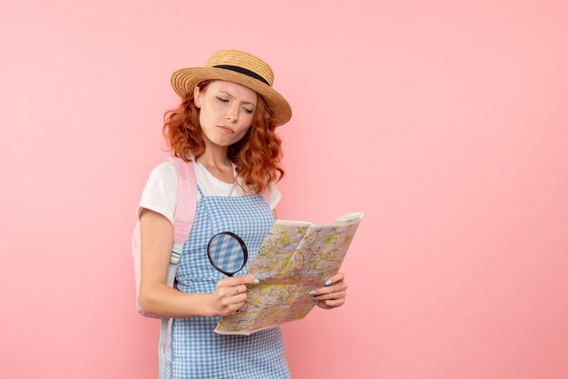 Вид спереди туристка с картой пытается найти направление в чужой стране