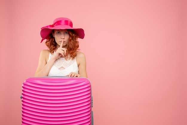 Foto gratuita vista frontale del turista femminile con borsa rosa sulla parete rosa