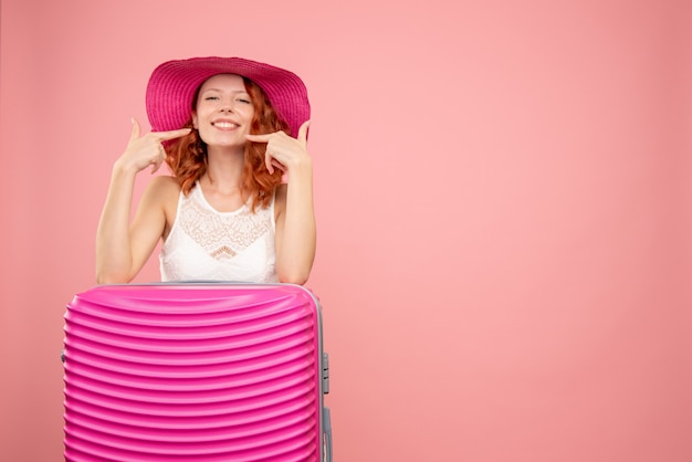 Foto gratuita vista frontale del turista femminile con borsa rosa sulla parete rosa