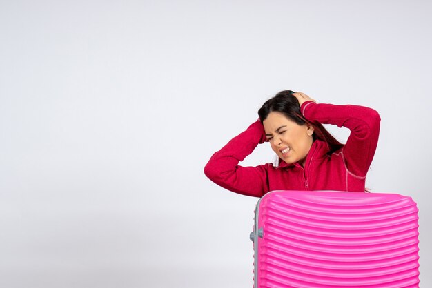 Front view female tourist with pink bag on a white wall