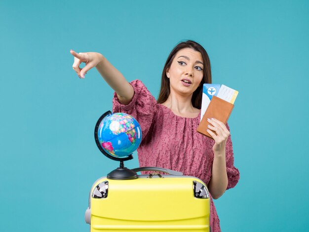 青い背景の海の旅の休暇の女性の旅の航海で彼女のチケットを保持している旅行の正面図の女性