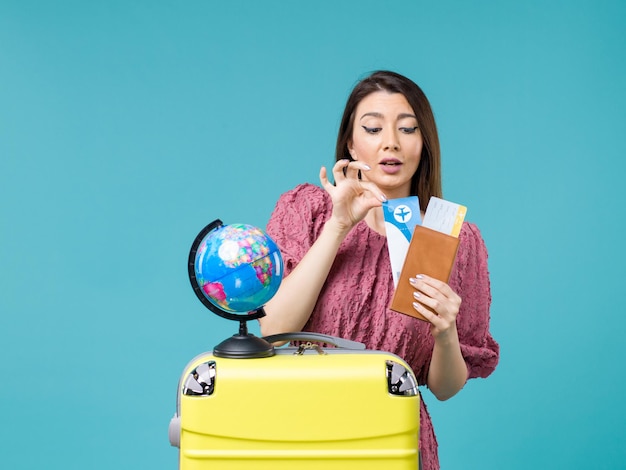 Front view female in trip holding her ticket on blue background sea trip woman voyage vacation journey