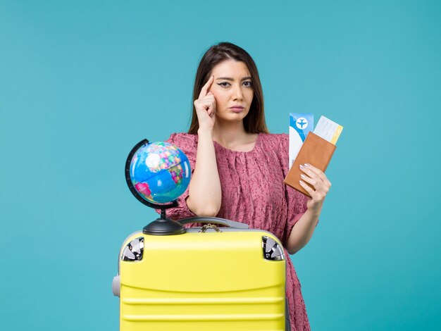 青い背景の海の旅の女性の航海の休暇の旅のチケットと財布を保持している旅行の正面図の女性