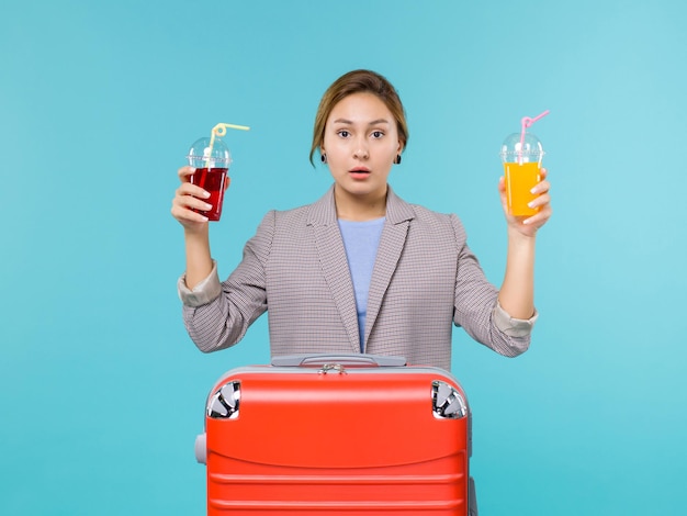 Вид спереди женщина в отпуске, держащая свежие напитки на синем фоне, путешествие, путешествие, отпуск, путешествия, гидросамолет