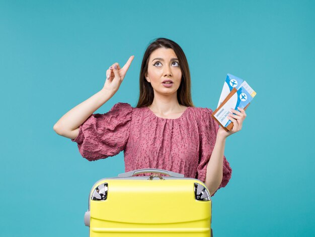 Front view female in vacation holding her tickets on blue background journey summer trip woman sea vacation human