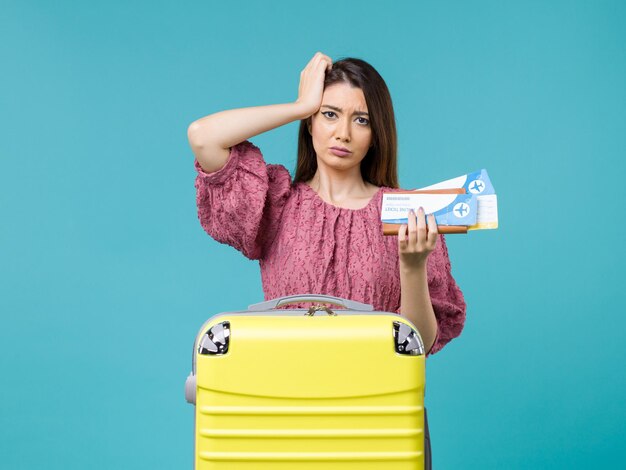 Front view female in vacation holding her tickets on blue background journey summer trip woman sea vacation