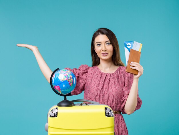 Front view female in vacation holding plane tickets on blue background sea vacation woman trip voyage journey