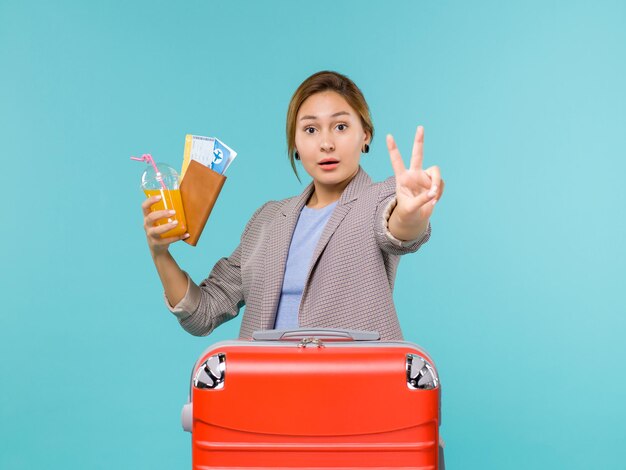 Front view female in vacation holding tickets on the blue background plane journey voyage sea trip