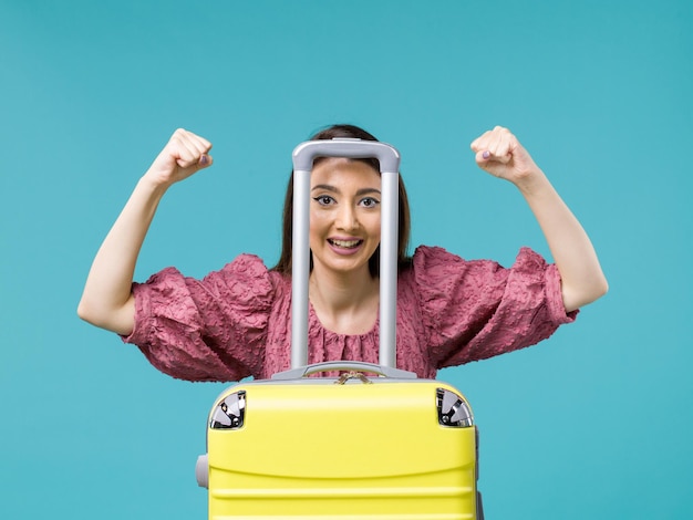 Femmina di vista frontale in vacanza con la sua grande borsa gialla sull'essere umano del mare della donna di viaggio di estate di viaggio dello scrittorio blu