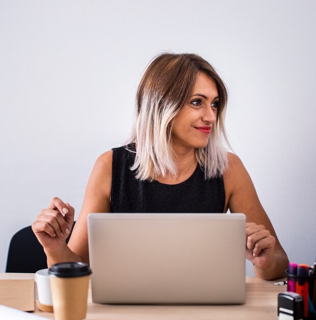 Front view female at work using laptop