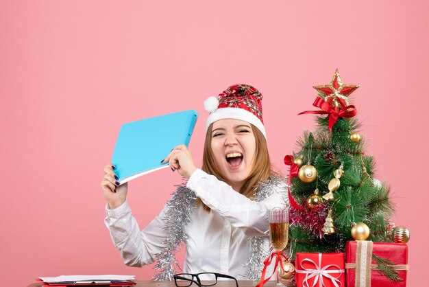 Front view of female worker holding documents feeling excited on pink