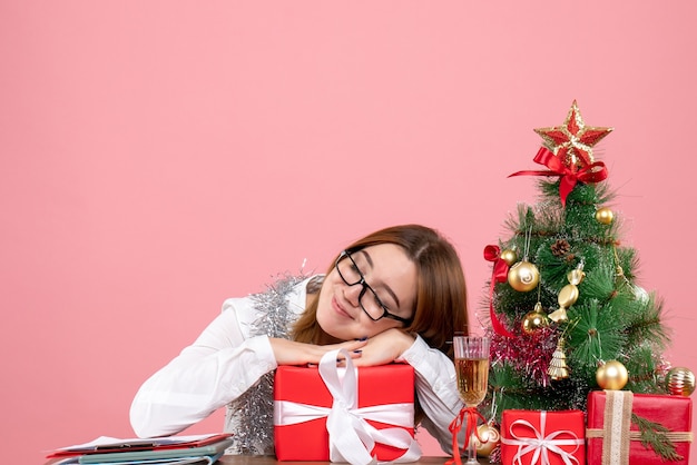 Front view of female worker holding present on pink