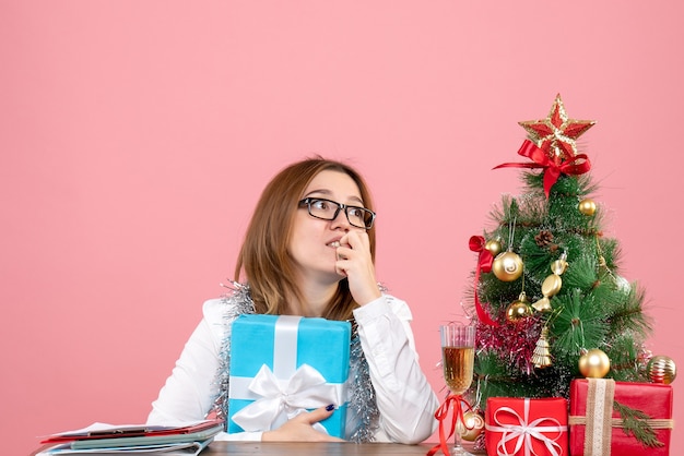 Front view of female worker holding present on pink