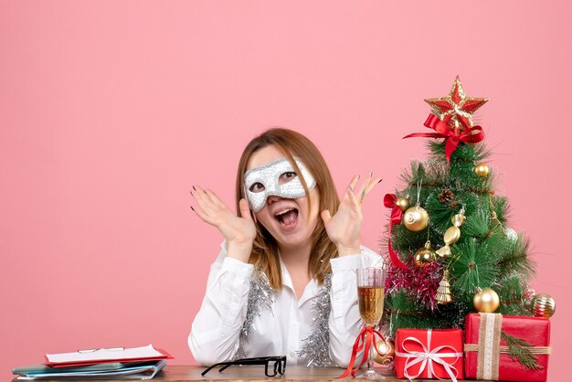 Front view of female worker in party mask on pink