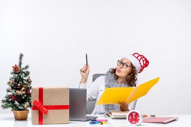 Front view female worker sitting before her place and working with documents