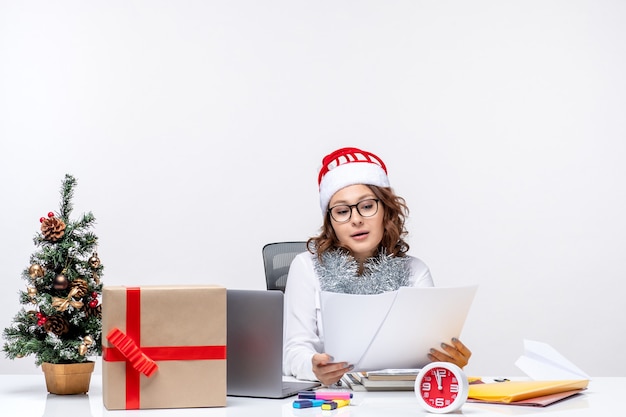 Front view female worker sitting before her table working with documents work business job office xmas