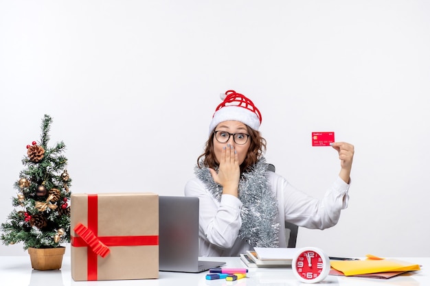 Front view female worker sitting before her working place holding bank card job business work christmas office