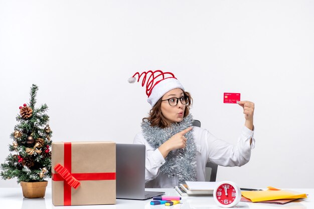 Front view female worker sitting before her working place holding bank card job business work christmas