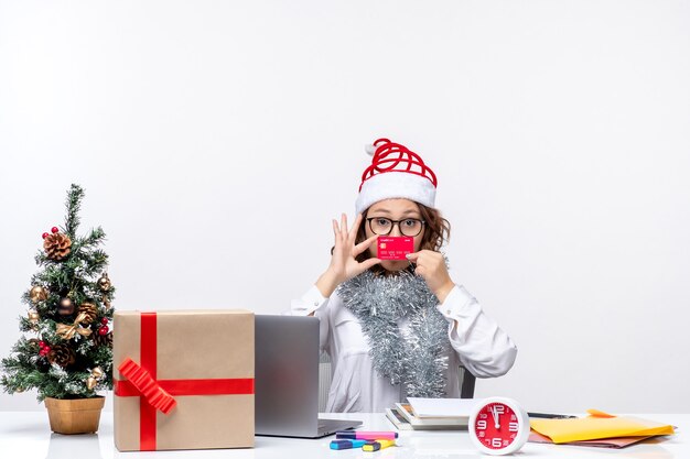 Front view female worker sitting before her working place holding bank card job business work office christmas