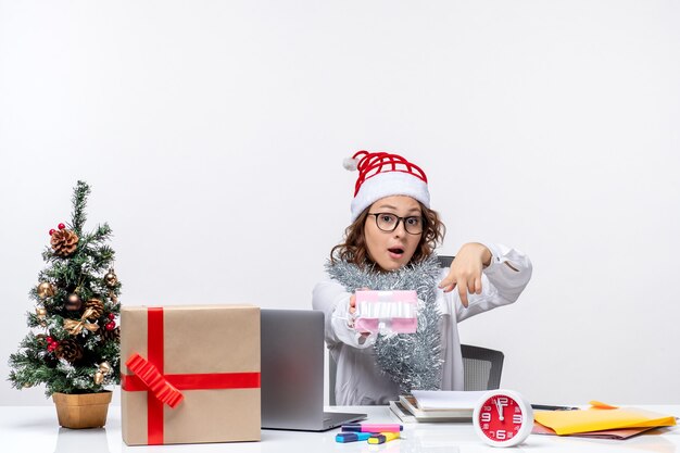 Front view female worker sitting before her working place holding little present