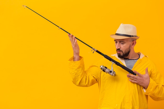 Foto gratuita vista frontale del pescatore che apprezza la sua canna da pesca