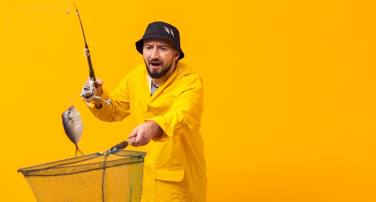 Free Photo front view of fisherman holding fishing rod and net with copy space